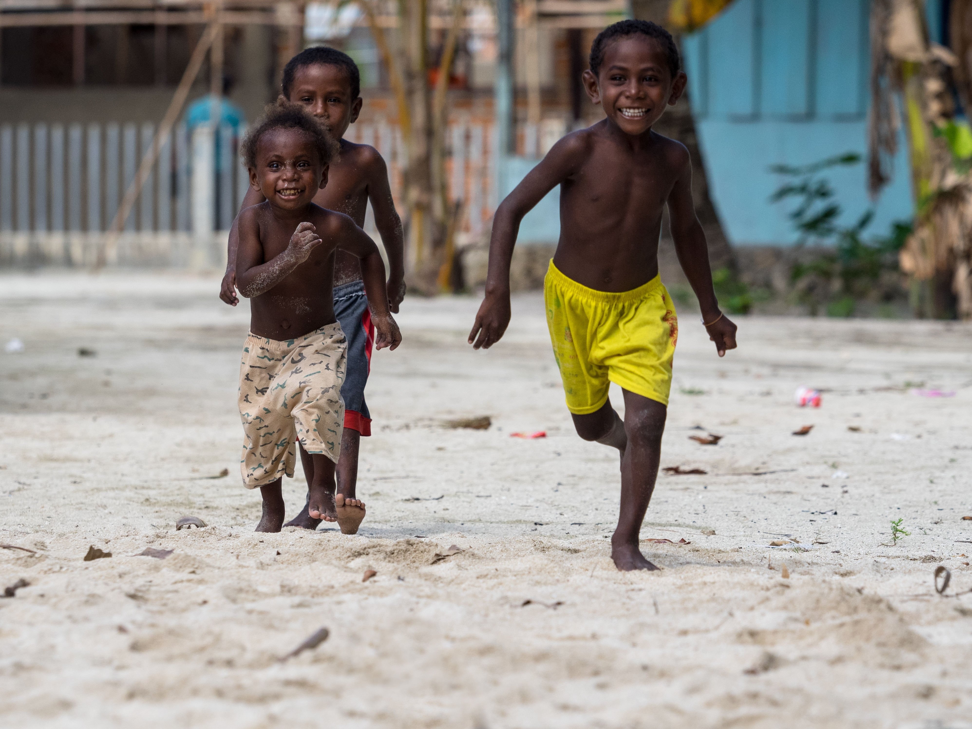 Village Kids of Raja Ampat running in the sand