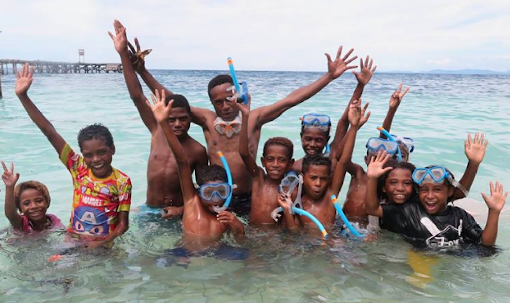 village kids of Raja Ampat in the water while snorkeling