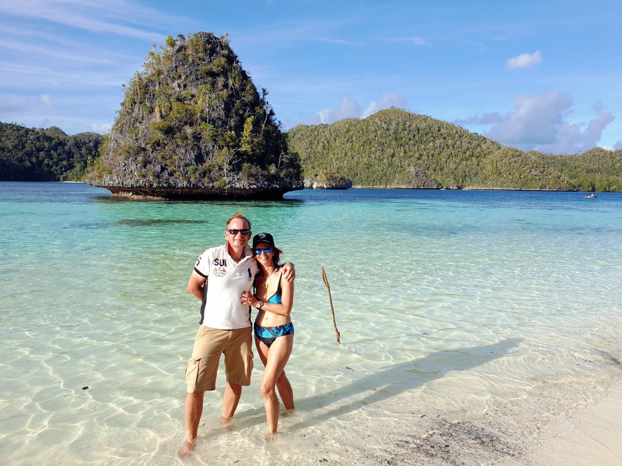 (English) two Papua Explorers Returning Guests on a white sand beach at the Wayag Islands in Raja Ampat
