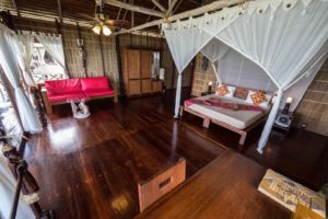 showing the bed, sofa and table inside one of our raja ampat overwater bungalows