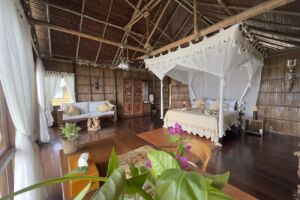 showing the bed, sofa and table inside one of our raja ampat overwater bungalows