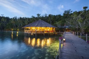 (English) our cozy restaurant built on the waters of Raja Ampat with lush rainforest in the back