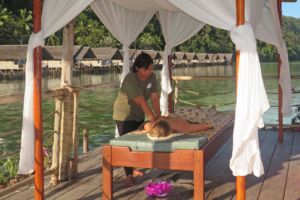 massage treatment with Papua Explorers bungalows in the background