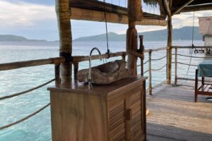 massage treatment with Papua Explorers bungalows in the background