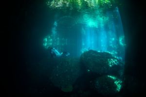 an underwater cave in the wall of the passage in raja ampat