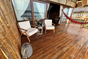 view from the balcony of our water bungalows in Raja Ampat with sun loungers in the front and our dive centre and islands of the Dampier Straight in the back