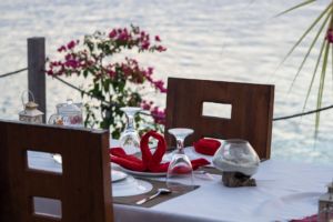 table set up on the Papua Explorers sundeck for a couples dinner with flowers in the background